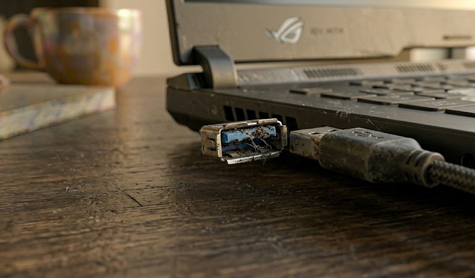 Close-up of a USB port on a laptop with a USB cable partially inserted